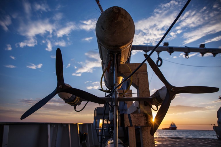The sunsets behind the Sirius UUV propellers as the vehicle waits to be completed on Falkor's work deck. 