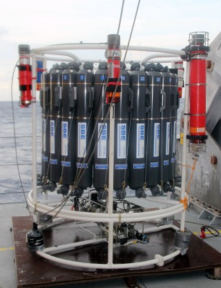 The grey cylinders with “SBE” on the side and numbered 1-24 around the top are the water samplers we use to collect seawater at specific depths in the ocean. The bright red “canisters” mounted on the outside are the navigation beacons we were testing. When we start work, we will have one of these on the CTD at all times, and another on Nereus, so that we can know – very accurately – where any of our instruments are at depth. For example, in today’s cast, while we lowered the CTD over the back of the ship it did not go straight down, vertically. Instead, because of the strong currents, by the time the CTD was at 2400m depth it was also 120m astern of the ship or, for scale, about 1 and a half times the length of the ship away.
