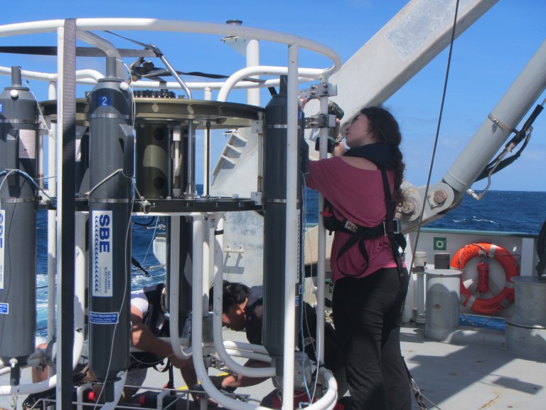 Gabi Pilo (right), Spencer Kawamoto and Ryan McDougall-Fisher take instruments off the CTD-cage on a rare sunny day during the transit to Hobart.