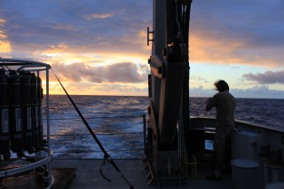 Postdoctoral fellow Arne Sturm taking a break from sampling to fish off the aft deck at sunset. 