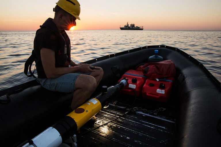 Andrew Durrant retrieves the Iver AUV, its strobes still flashing, near sunset. 