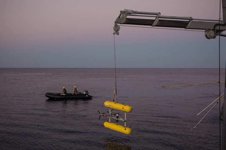 Professor Stefan Williams and Deckhand Erik Suits watch from a zodiac as AUV Sirius is recovered to the aft deck.