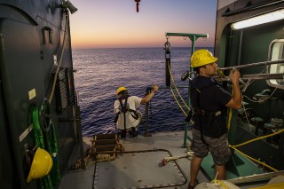 Angelos Mallios helps load in AUV’s as dusk falls.