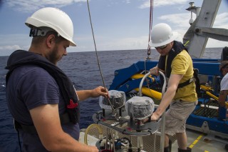 The McLane pumps are part of the technology being used to get samples from the depths of the ocean. Here being deployed by deckhand Hans Schonherr and analytical chemist Matt McIlvin.