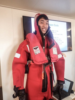 One of the many things Caleb has had the opportunity to learn and experience: safety drills before sailing. Here he learns how to proper prepare and wear an emrgency immersion suit.