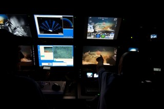 ROV technicians and the led scientist of the dive work together in the ROV control room.