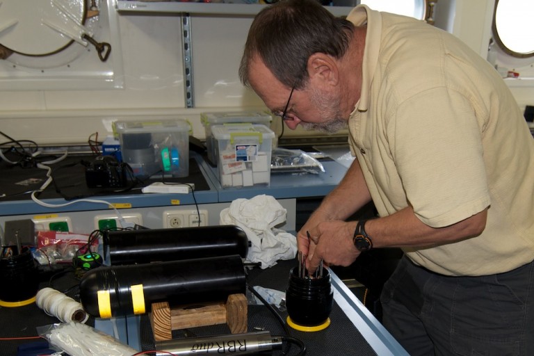 Chief scientist Ian MacDonald prepares a Video Time Lapse Camera to be mounted on the multicore frame.