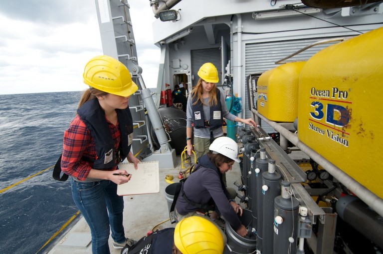 The coral team extracts cold seawater collected at depth by the Niskin bottles on the ROV for their experiments with live coral specimens.