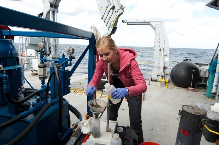 Postdoctoral researcher Sara Kleindienst rinses the sediment samples into bottles that she'll take back to the laboratory to analyze.