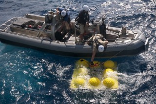 R/V Falkor crew attach lines to the OC26 lander in preparation to recovery from the water by ship's crane.