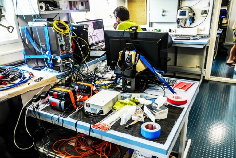 Researchers unpack gear in Falkor's Dry Lab in preparation for the Virtual Vents expedition.