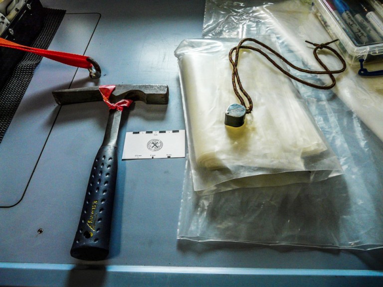 The analytical equipment of geologists: rock hammer, hand lens, sample bags and scale card.