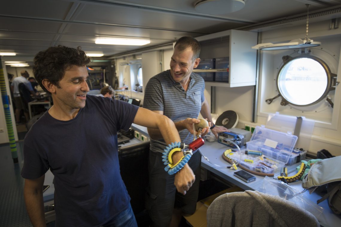 Daniel Vogt tests the newly engineered ‘squishy fingers’ on David Gruber. These will be used to gently interact with the coral and creatures of the deep ocean.