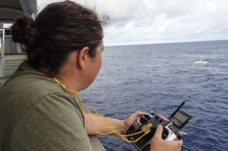 Oceanographer Mariana Ribas drives the remotely controlled catamaran. One of the parts of the catamaran was damaged during recovery, but it took less than five minutes for Falkor's crew to create a new piece and put the instrument back in the water.