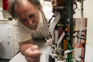 Peter Keen assists resident scientists in the repair of one of their instruments