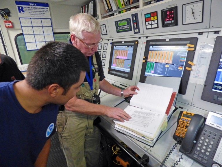 Science Crew A.J. Reyes and Chief Engineer Allan Watt in the Engineering control room reviewing specifications. 