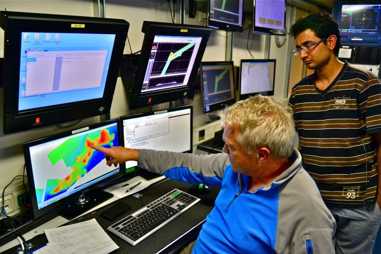 Andre Droxler, lead geologist, points at the location for tomorrow's first dive as grad student Pankaj Khanna looks on. 