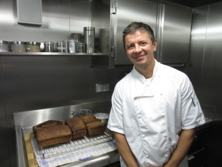 Chef Arkadiusz in the ship bakery with fresh bread hot from the oven.