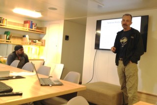 Dr. Sager meets with his team in the ship’s library.