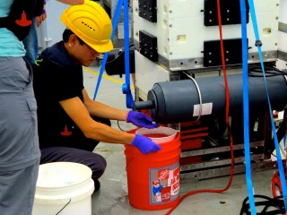 Undergraduate student Than Kyaw collecting a water sample from one of the lander bottles. 