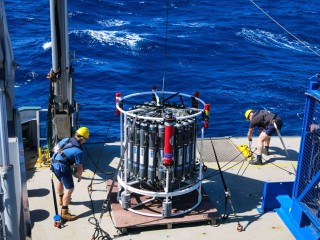 CTD Rosette on board the aft deck of Falkor about to be deployed by research technicians Carlin Bowyer (left) and Anton Kuret (right)