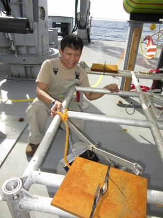 Engine room fitter Dante with the "jaws" he manufactured for the Rock Grabber lander.