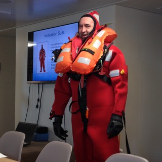 Safety first! Cruise leader Professor Grey Ivey volunteered to demonstrate the immersion suit