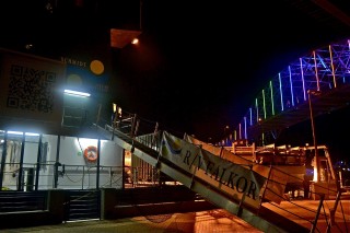 R/V Falkor at the dock in Corpus Christi, with the neon lights of the Harbor Bridge as a backdrop.