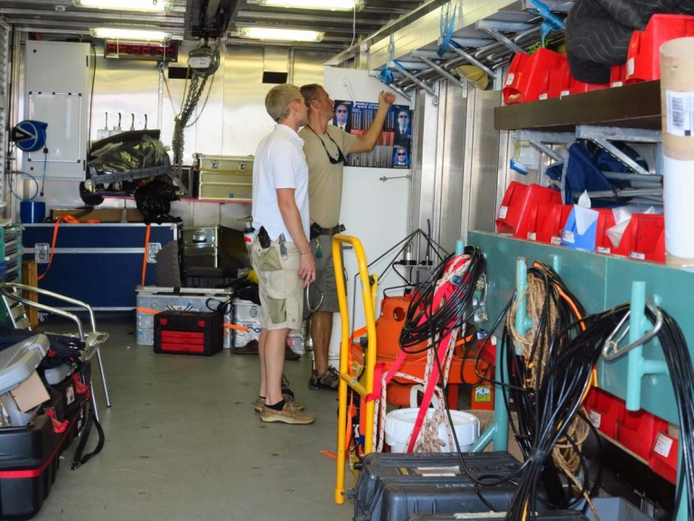 Chief Officer Paul Shepherd and Bosun Lars Toensfeldt scan the shelves for retrieval instruments in the deck workshop.