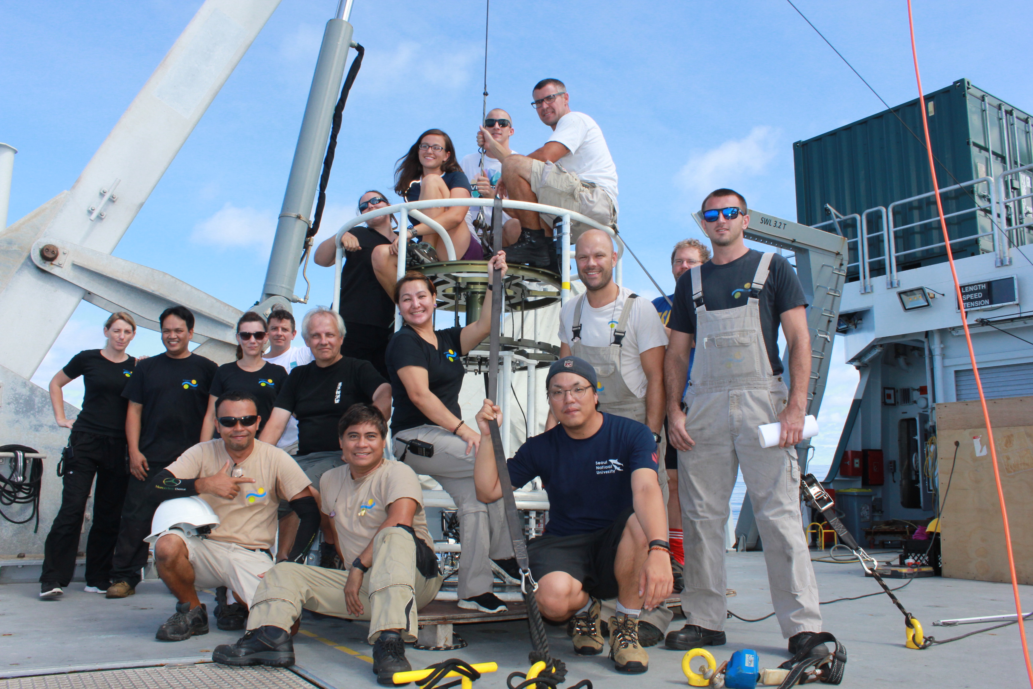 Falkor crew and science team pose for a photo with the CTD Rosette, the star of this cruise. 