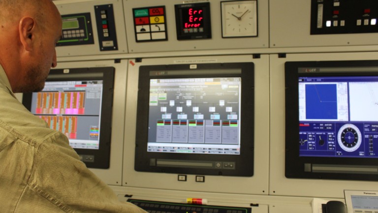 Chief engineer, Miro Mirchev points to the three screens on the panel showing the ships fuel oil levels (far left), power management system (middle) and the captains screen (far right). 