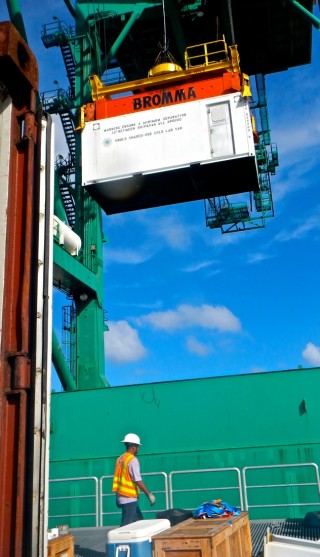 The port crane removing the cold van laboratory from Falkor's deck. 