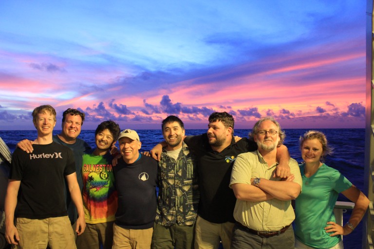 AUV Sentry team and R/V Falkors marine techicians take a moment to enjoy the last sunset of the cruise (Left to right: Zac Berkowitz, Chris Taylor, Justin Fujii, Dana Yoerger, James Cooper, Leighton Rolley, Peter Keen, and Johanna Hansen).