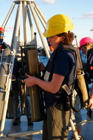 Graduate student Maggie Esch carries a core liner filled with sediment collected by the multicore instrument in about 1650m depth.