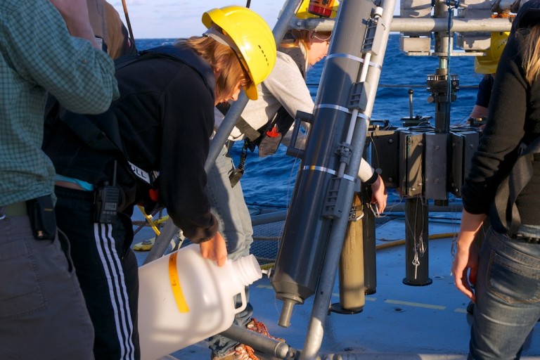 Graduate student Carolin Dewald transfers seawater collected at depth from a Niskin bottle mounted on the multicore instrument frame.