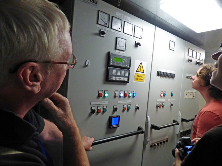 Chief Engineer Allan Watt with Science Crew Amelia Travers and Nick Adams viewing buttons we should not touch on the tour. 