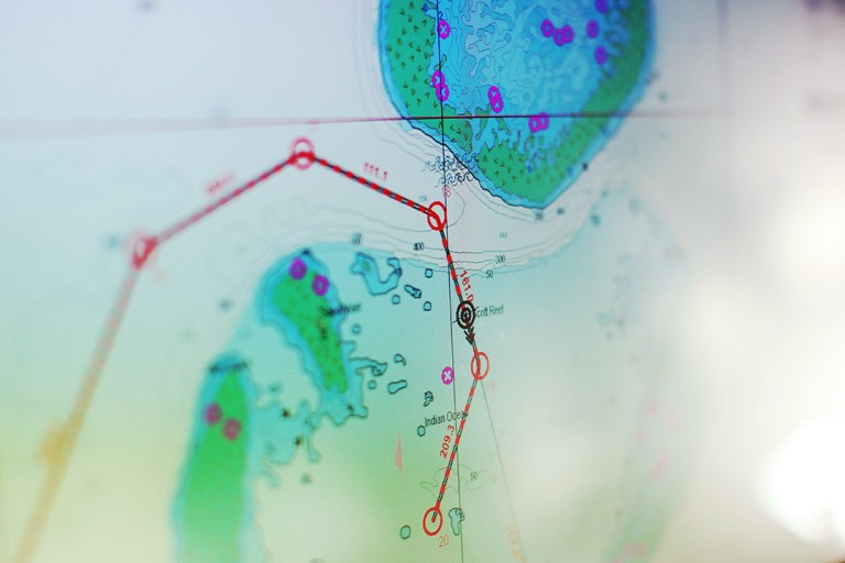 Second Officer Oliver Hurdwell looks over digital navigational maps on the bridge as Falkor approaches its first destination at Scott Reef. 