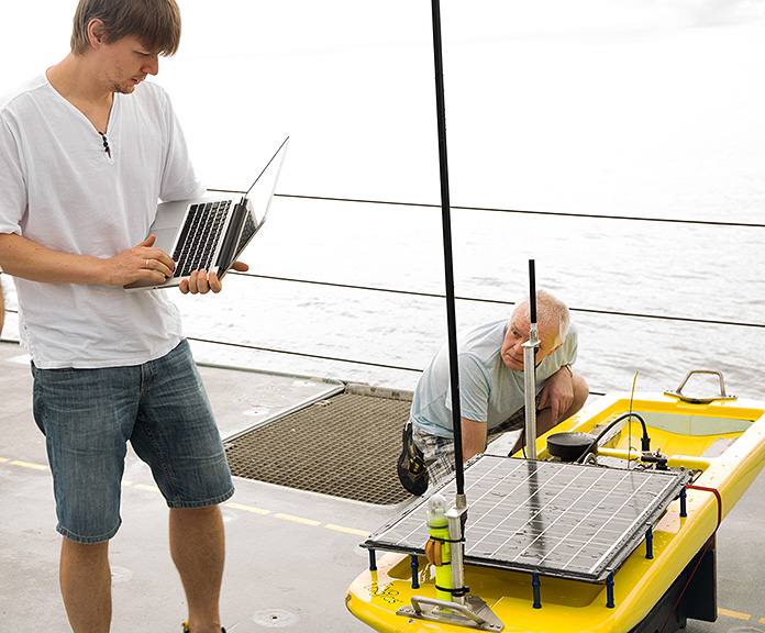 Oleksiy Kebkal and Georgiy Pleskach of Evologics run tests and prepare the Wave Glider’s modem for optimal performance at sea.