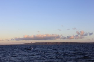 Scientists stopped to appreciate a beautiful sunset on the Kaiwi Chanel with a view of Molokai on the last evening on board Falkor.